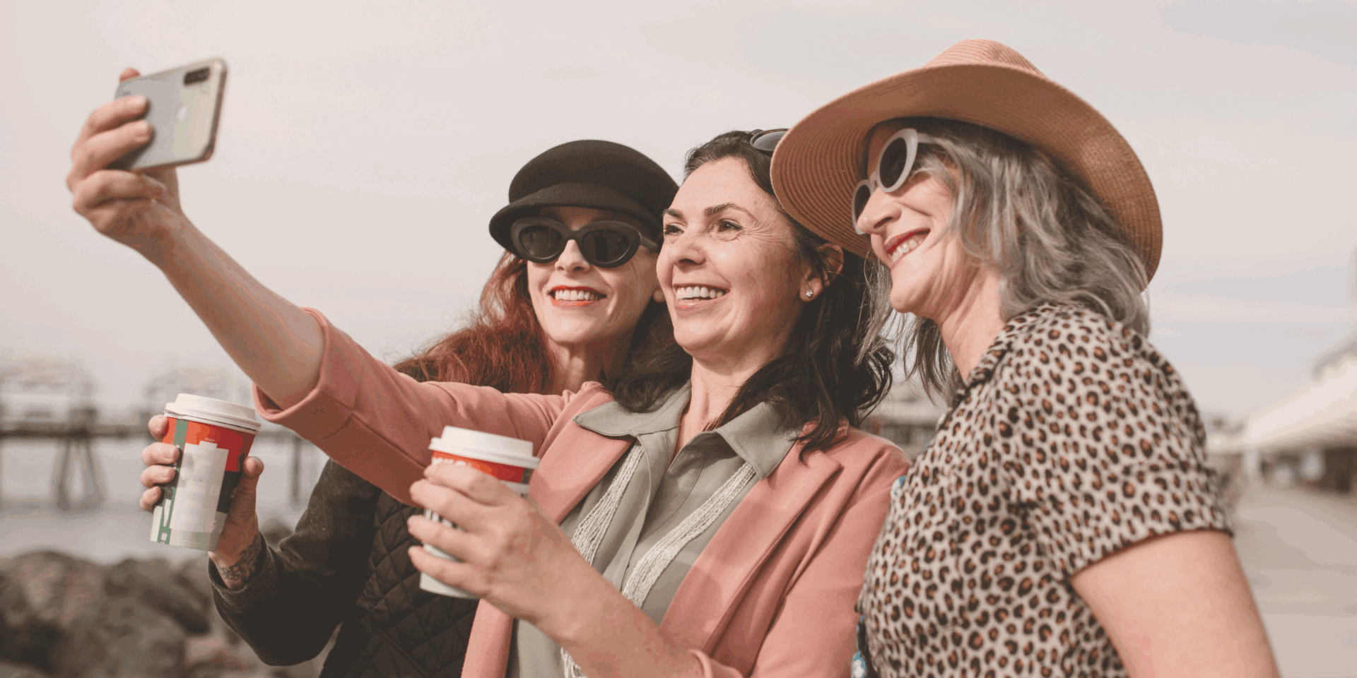 Three women smiling taking a selfie.